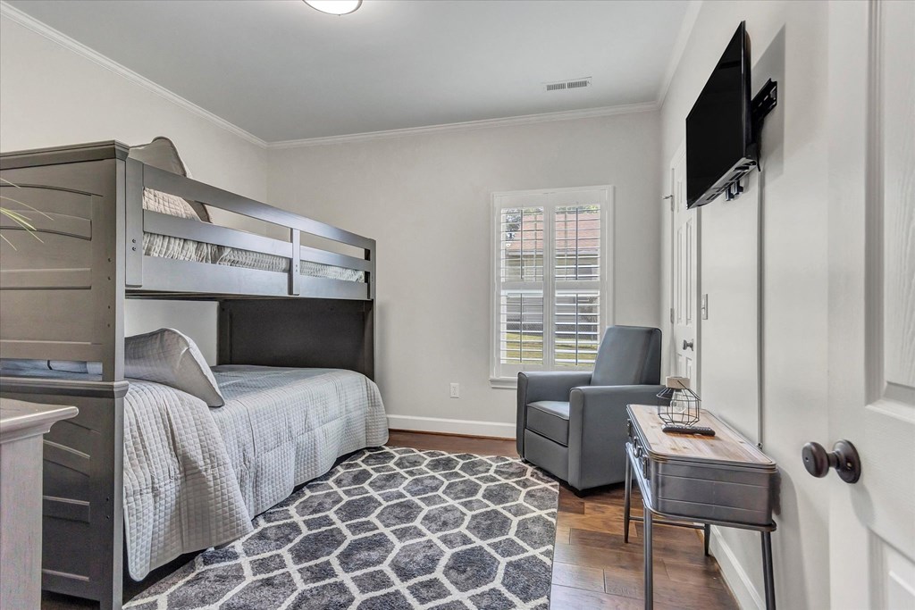 a bedroom with a bunk bed and a desk with a chair