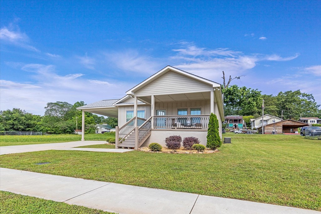 the front of a house with a lawn and a sidewalk