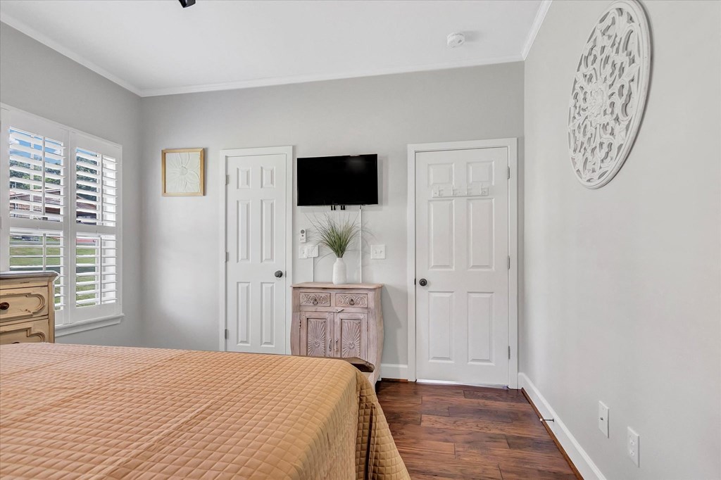 a bedroom with a bed and two doors and a tv