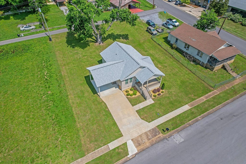an aerial view of a house with a gray roof and a green lawn
