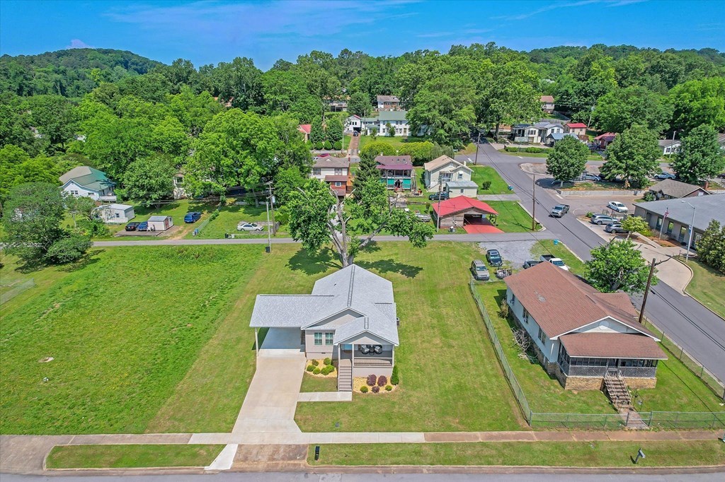 an aerial view of a neighborhood with houses and lawns and trees