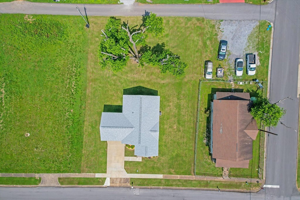 an aerial view of a house with a yard and a tree