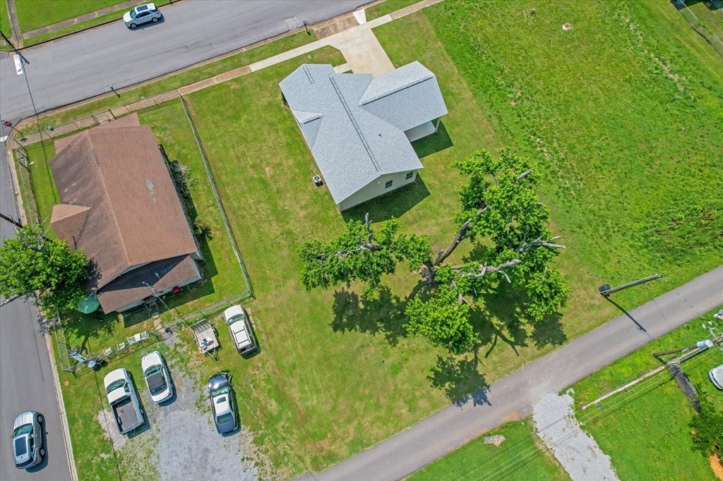 an aerial view of a house and a church and a street with cars