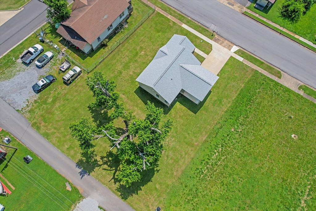 an aerial view of a house with a yard and a street