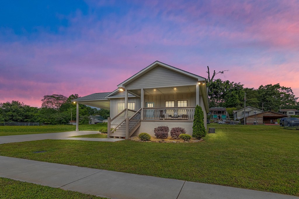 a home with a porch and a pink and blue sky