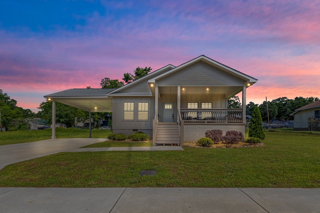 a home with a porch and a sunset in the background