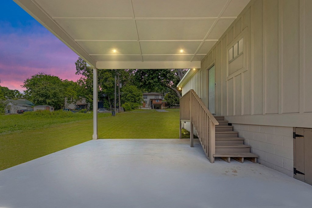 a covered porch with stairs on the side of a house