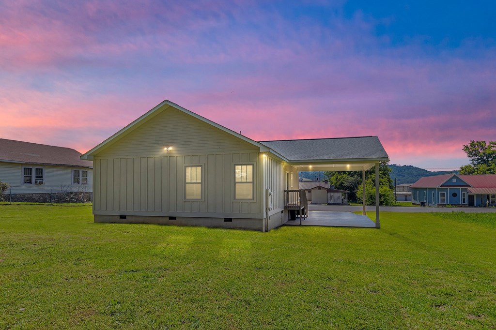 a manufactured home with a yard and a pink sky