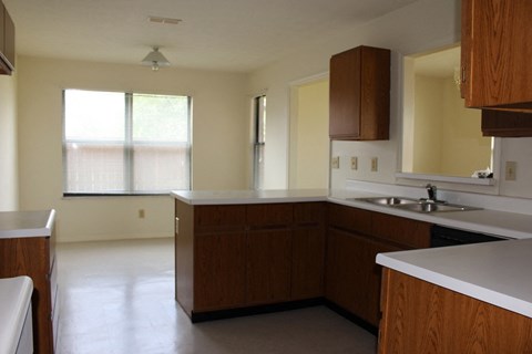 A kitchen with brown cabinets and a white counter.