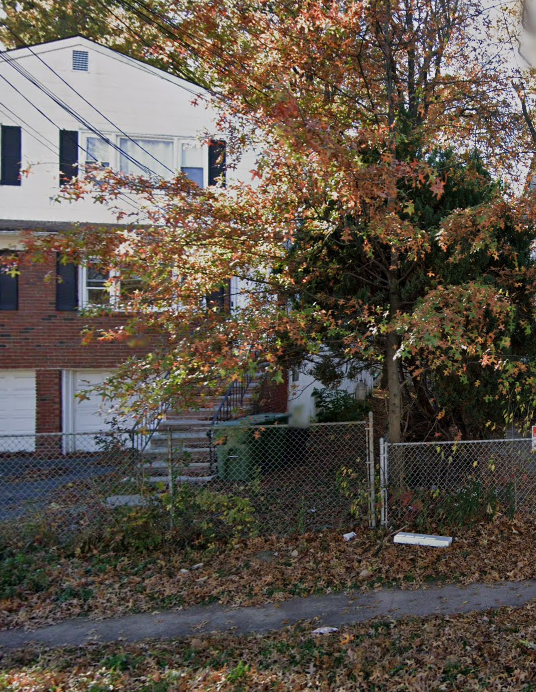 a tree and a fence in front of a building