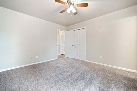 a living room with carpet and a ceiling fan