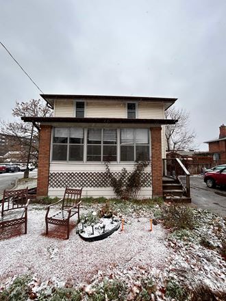 a house with a yard and two chairs in the snow