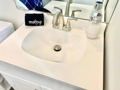 a bathroom sink with a soap dispenser and a mirror