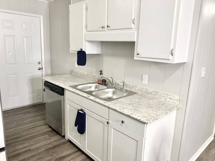 a white kitchen with white cabinets and a sink