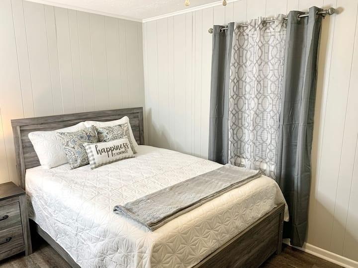 a bedroom with a bed and a window with curtains