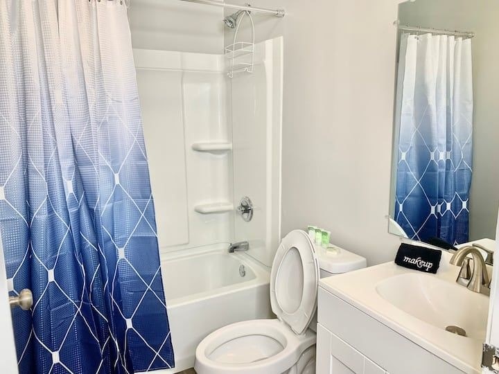 a white bathroom with a blue shower curtain