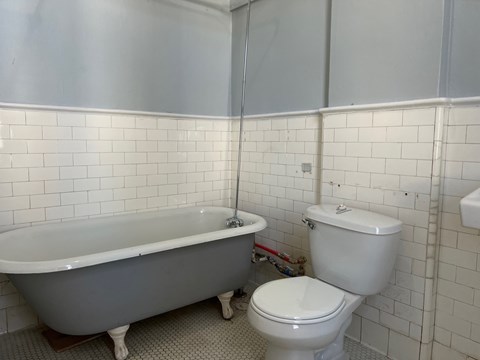 A white toilet sits next to a bathtub in a bathroom.