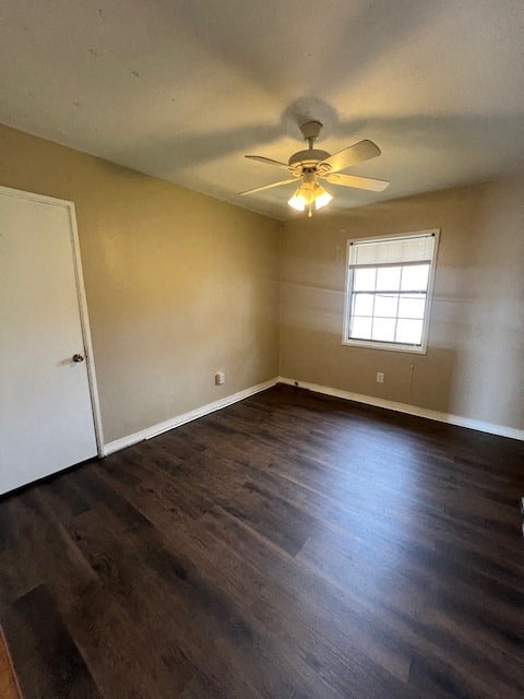 an empty living room with a ceiling fan and wood floors