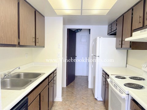 A kitchen with a sink, stove, and refrigerator.