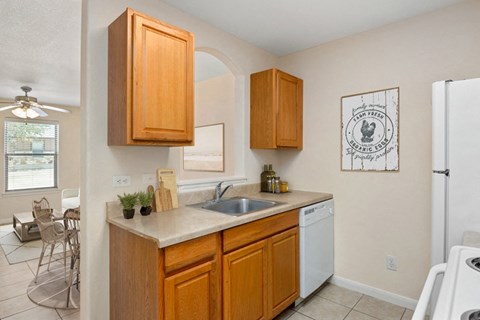 a kitchen with wooden cabinets and a sink and a refrigerator