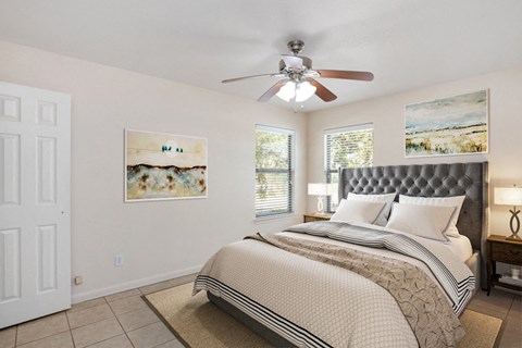 the master bedroom has a large bed and a ceiling fan