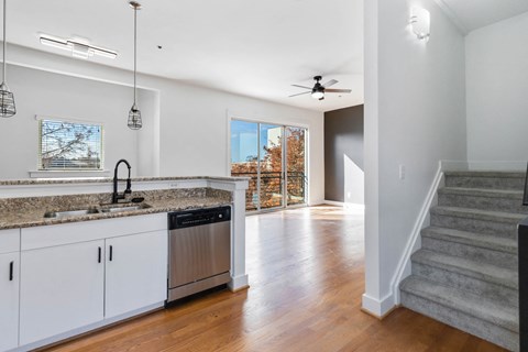 A kitchen with white cabinets and a granite countertop.