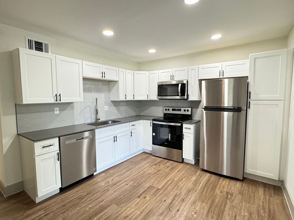 A kitchen with white cabinets and stainless steel appliances.