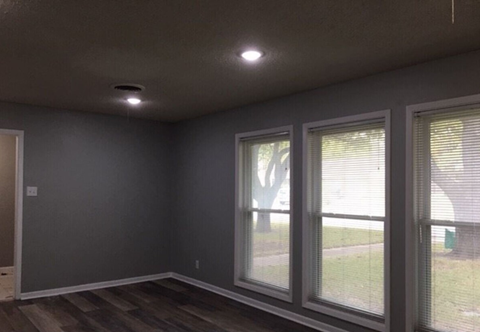 a living room with large windows and a wooden floor