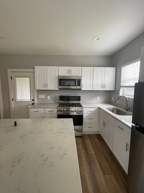 a kitchen with white cabinets and stainless steel appliances