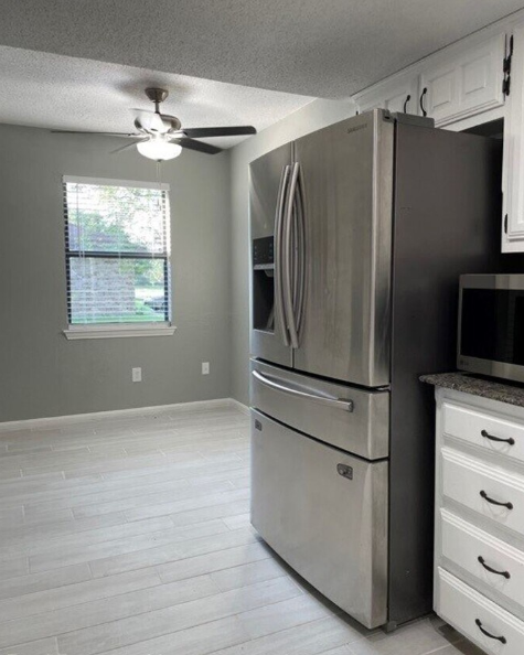 a kitchen with a stainless steel refrigerator and a ceiling fan
