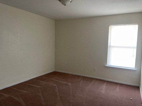 an empty room with a window and a tiled floor
