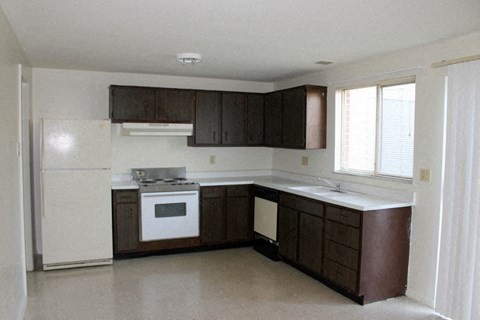 A kitchen with brown cabinets and a white fridge.