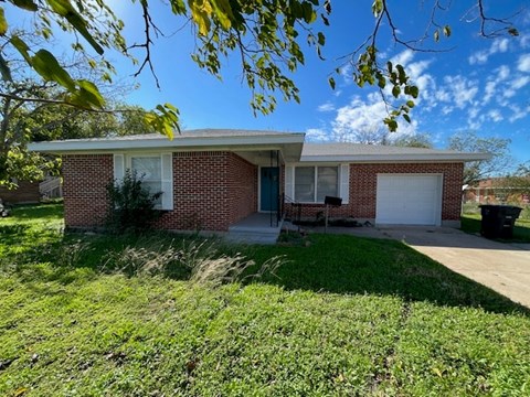a small brick house with a white garage door