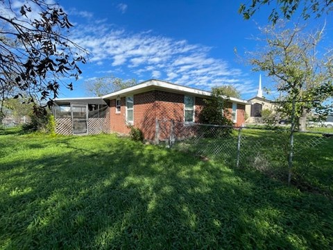 a brick house with a fence in front of it