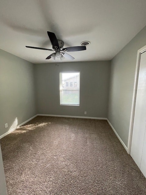 an empty room with a ceiling fan and a window
