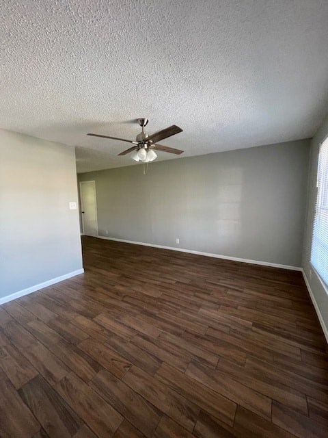 an empty living room with wood floors and a ceiling fan