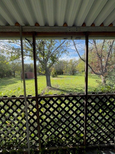 a porch with a view of a field and a tree
