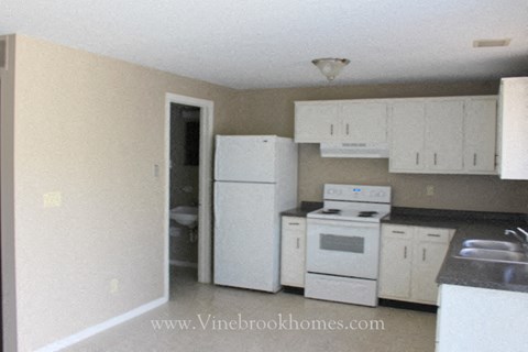 a white kitchen with white appliances and white cabinets