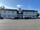 a large white building with cars in front of it