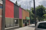 a colorful building on a city street with a car