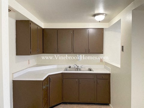 A kitchen with brown cabinets and a white countertop.