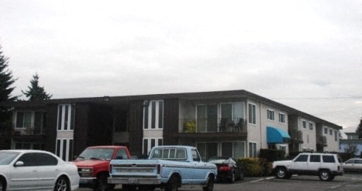 an apartment building with trucks parked in a parking lot
