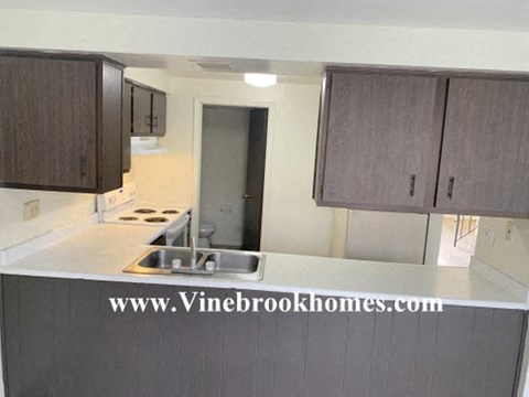 A kitchen with brown cabinets and a sink.