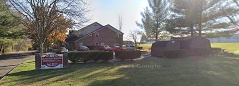 a house with a sign and cars parked in front of it