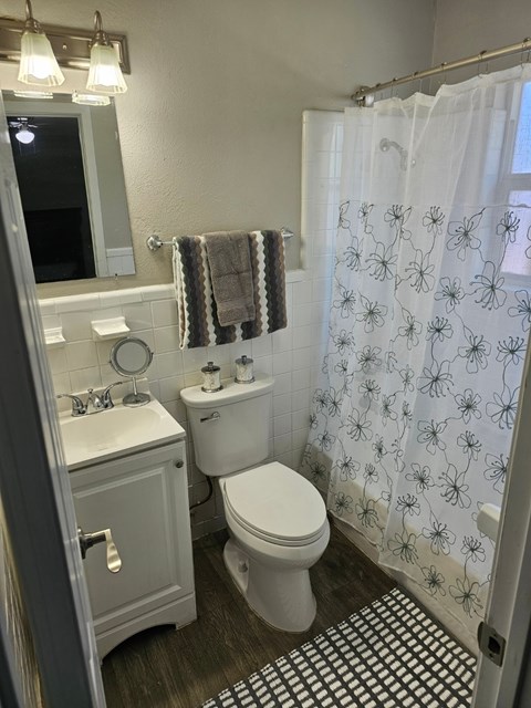 A white toilet sits next to a sink in a small bathroom.