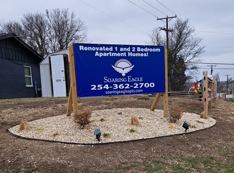 A sign for Soaring Eagle Apartment Homes is displayed in front of a building.