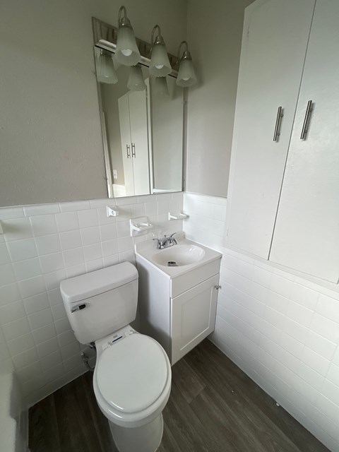 A white toilet and sink in a small bathroom.