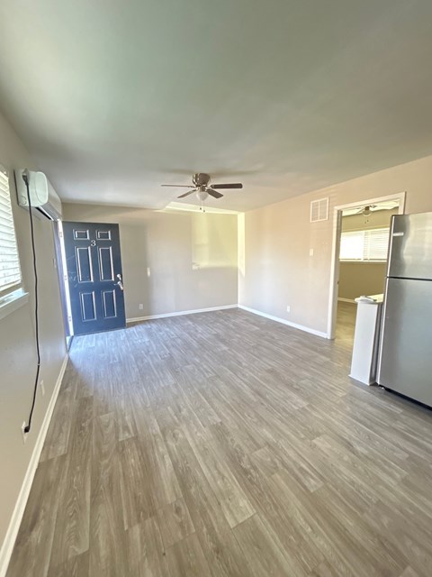 A room with a ceiling fan and a door.