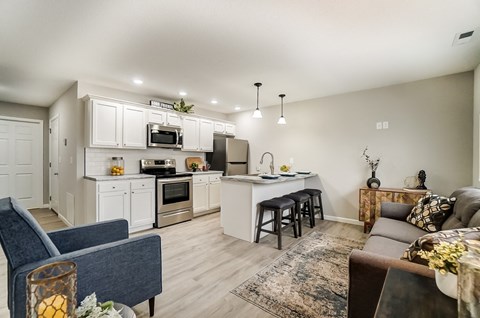 A modern kitchen with a blue chair and a brown couch.