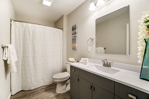 A bathroom with a white shower curtain and a white toilet.